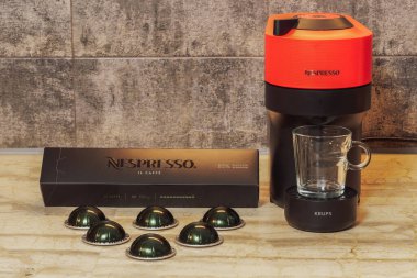 Selanik, Yunanistan - 7 Aralık 2022: Otomatik Nespresso Vertuo Pop makinesi alüminyum kapsüllerle espresso yapımında kullanıldı. Krups kahve makinesinin etrafındaki metal 2 kafe kapsülleri damlatan kahve yapmak için..