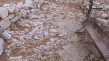 Day pan to an old low-rise stone-built damaged house with red tiles at Prespes lake area, Greece.