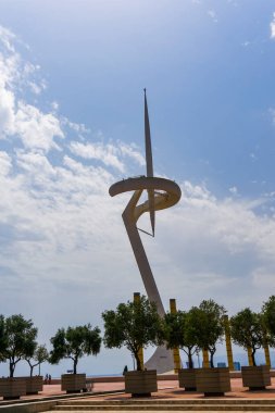 Barselona, İspanya - 23 Temmuz 2017: Montjuic İletişim Kulesi güneş ışığı altında ağaçlarla çevrili ve İspanya 'da bulutlu bir gökyüzü.