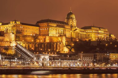 Budapeşte, Macaristan Tuna nehrinin kıyısından görülen Budin Kalesi 'nin gece görüşünü aydınlattı.