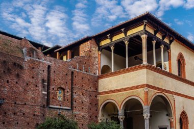 Milan, İtalya Ducal Avlusu Sforzesco Kalesi 'nin alçak açılı gündüz manzarası - Castello Sforzesco - Ortaçağ apartmanları konutu, Galeazzo Maria Sforza' nın loggiası şişkin bulutlu gökyüzüne karşı.