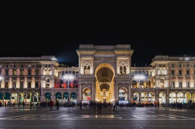 Milan, İtalya - 24 Şubat 2019: Düşük açılı geniş açılı gece Galleria Vittorio Emanuele II, 19. yüzyıl atari salonu dükkan cepheleri ve Duomo ana meydanında tanımlanamayan kalabalık.