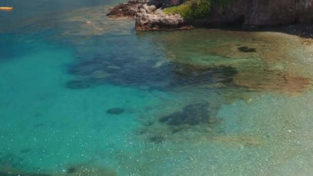 ギリシャのセファロニア島の穏やかな海によって低上昇カラフルな家や居酒屋と伝統的な沿岸アソスの村で喘ぐ — ストック動画