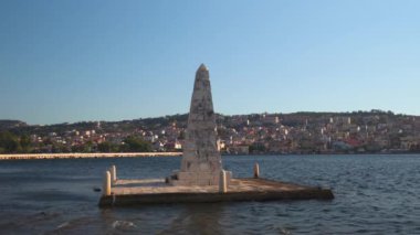 Argostoli şehir panoramasının yer aldığı De Bosset Köprüsü 'nün yanındaki 1813 taş kaplı dikilitaşlı dikilitaş, Yunanistan' ın İyon Adası 'nın arka planında yer alıyor..