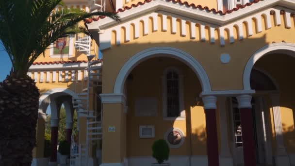 希腊塞法洛尼亚爱奥尼亚岛上Argostolion镇 由阿西西西的圣方济各建造的带有钟塔的前天主教东正教五彩斑斓的圣母教堂正面 — 图库视频影像