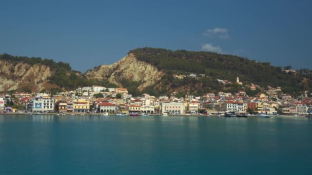 Zakynthos 希腊岛屿首都城的风景航行景观 低矮的海滨建筑紧邻平静的大海 在岩石山下 — 图库视频影像