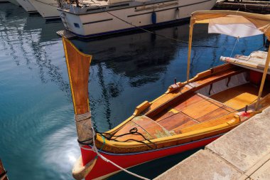 Önü belirgin Dghaisa tal-pass, geleneksel Malta su taksi teknesi kalabalık olmadan Birgu, Malta rıhtımına demirlemiş.