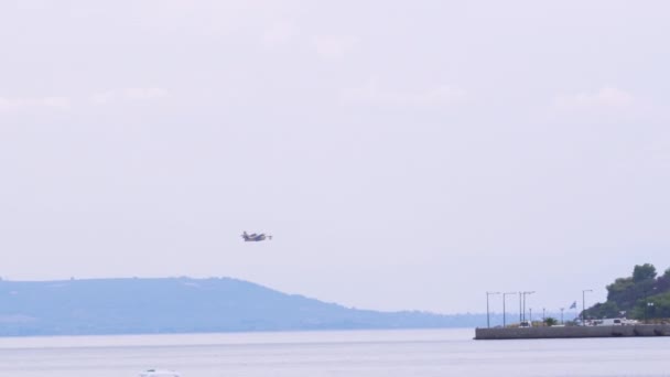 希腊Theologos 2023年8月26日 一架希腊两栖消防加拿大涡轮螺旋桨发动机水上飞机 红色和黄色伪装 低空飞行在海滨房屋上方 — 图库视频影像