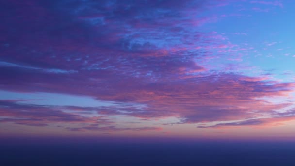 ピンクとオレンジ色の雲の下を飛ぶ日の出の旅は フレームの右側を見ています 高高度でクルージングする航空機に乗って朝の地平線の旅客の窓の眺め — ストック動画