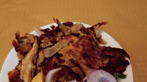 希腊陀螺猪肉切碎的部分 配上洋葱圈和芥末 放在盘上的特大盘上 — 图库视频影像