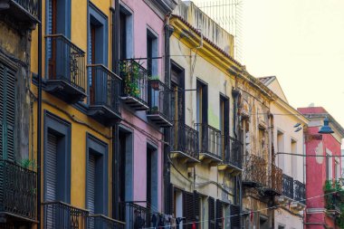İtalya 'nın Sardunya Adası' nda ahşap pencere panjurları ve demir balkonları olan Cagliari tarihi merkez renkli binalar..