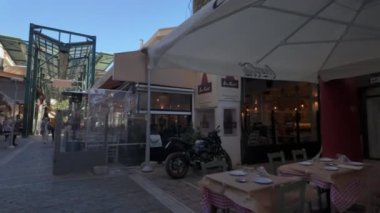 Selanik, Yunanistan - 8 Nisan 2024: Athonos bölgesindeki geleneksel açık hava taverna restoranlarında insanların yemek yediği günlük Yunan POV yürüyüş sahnesi. 