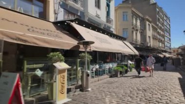 Selanik, Yunanistan - 8 Nisan 2024: Yunan günlük POV yürüyüşü insanların Aşağı Ladadika bölgesindeki geleneksel açık hava taverna restoranlarında yemek yedikleri sahne.