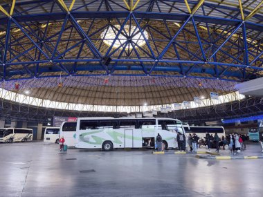 Selanik, Yunanistan - 23 Aralık 2024: Makedonya Şehirlerarası KTEL Otobüs Terminali Yolcu ve koçlarla dolu Kubbeli bir çatı altında.