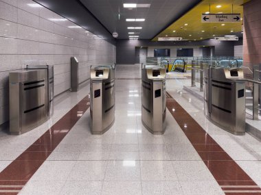 Selanik, Yunanistan - 21 Aralık 2024: Thess Ticket toplu metro taşımacılığı Elektronik turnikeler ve modern mimari tasarımın yer aldığı otomatik metro giriş alanı.