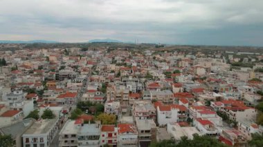 Yunanistan 'ın Nea Michaniona kentindeki tipik küçük kıyı kasabasının panoramik havası, alçak katlı evler ve yukarıda bulutlu gökyüzü.