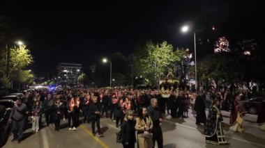 Selanik, Yunanistan - 18 Nisan 2025: İyi Cuma Ortodoks Paskalya Geçidi. Epitafios 'un şehir merkezinin sokaklarında çiçeklerle süslenmiş anma törenine katılanlar.