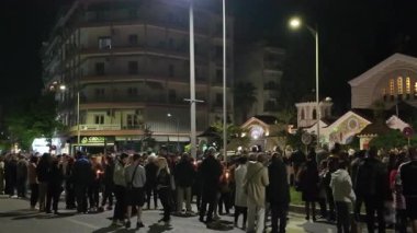 Selanik, Yunanistan - 18 Nisan 2025: İyi Cuma Ortodoks Paskalya Geçidi. Epitafios 'un şehir merkezinin sokaklarında çiçeklerle süslenmiş anma törenine katılanlar.