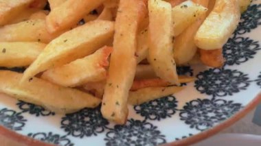 Taze yapılmış altın patateslerden marine edilmiş ançüez balıklarına kadar tepetaklak yiyecekleri canlı yeşil soslar ve bitkilerle süslenmiş beyaz bir tabakta ustaca hazırlanmış balık filetoları..