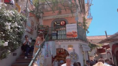 Positano, İtalya - 15 Haziran 2024: Ziyaretçiler gün ortası boyunca canlı mimari ve canlı atmosferle çevrili Positano, İtalya 'nın dar ve büyüleyici şeritlerini keşfediyorlar..