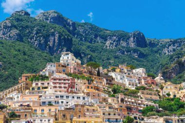 İtalya 'nın Amalfi Sahili' ndeki çarpıcı uçurum kenarındaki Positano köyünü keşfedin. Dramatik dağlara ve yemyeşil yeşilliklere yuva yapmış renkli binalar..