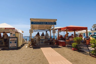 Positano, İtalya - 15 Haziran 2024: Tekne kiralama standında ziyaretçiler, güneşli Amalfi Sahili 'nin keyfini çıkarıyorlar.