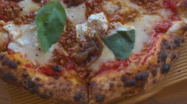 Lezzetli et, kremalı peynir, vişneli domates, kabak ve taze fesleğen ile kaplı lezzetli pizza varyasyonları yerel bir lokantada servis ediliyor..