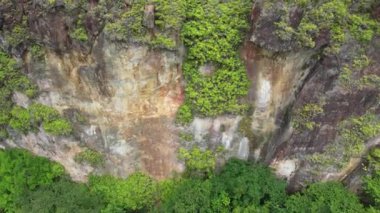 Filipin köyü, tropikal bir adadaki nehrin kıyısında bir dağ insansız hava aracının arkasından uçuyor. Yüksek kalite 4k görüntü