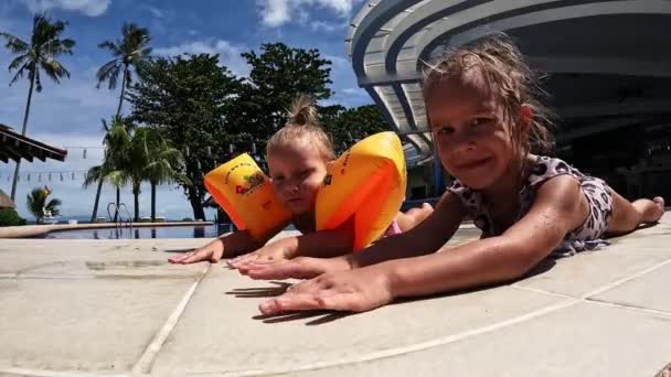 Μικρά Δίδυμα Κορίτσια Κάνουν Ηλιοθεραπεία Στην Άκρη Της Πισίνας Υψηλής — Αρχείο Βίντεο
