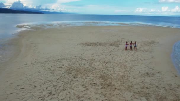 三个姐妹 三胞胎 双胞胎手牵手在白沙滩上奔跑 沙滩上有云朵 浅滩的痕迹 还有热带岛屿上的三胞胎姐妹沿着沙滩奔跑 — 图库视频影像
