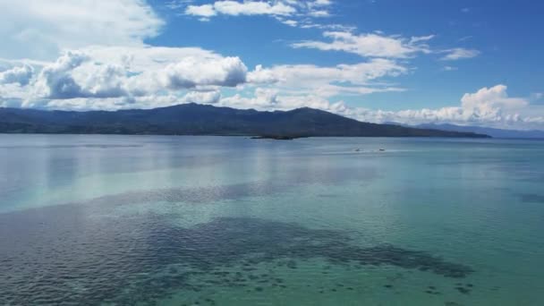 Baisフィリピン白い砂が熱帯の山の島々の間に干潮を吐き出す青い海の水のボート山の雲 — ストック動画