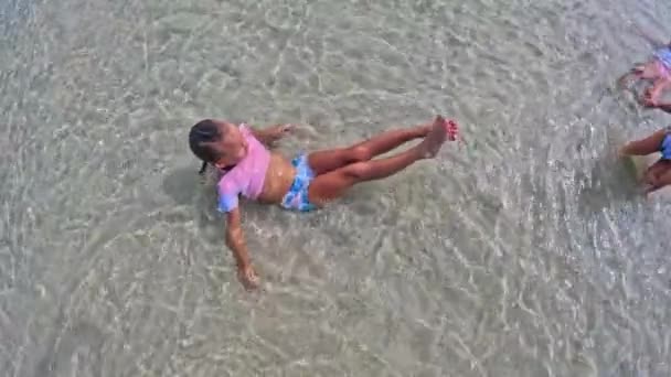 女の子は水の上に横になることを学ぶ 高品質4K映像 — ストック動画