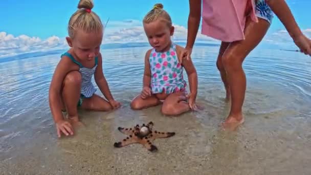 Sorelle Triplette Che Giocano Con Stelle Marine Sulla Spiaggia Filmati — Video Stock