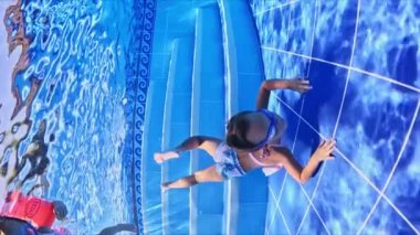 3-5 yaşlarındaki küçük kız havuzda yüzme gözlükleriyle yüzmeyi öğreniyor küçük kız havuzda gözlüklerle yüzüyor. Yüksek kaliteli FullHD görüntüler