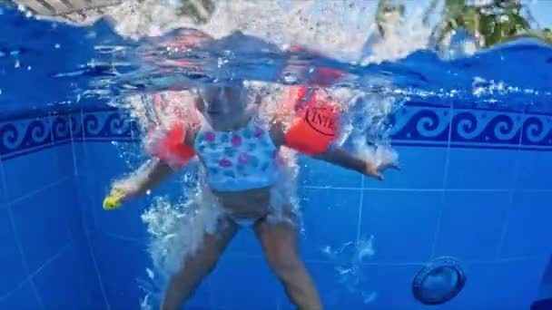 Een Klein Meisje Springt Van Zijkant Het Zwembad Volledig Ondergedompeld — Stockvideo