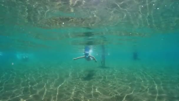 マスクとシュノーケルで海で泳ぐベビーガール 高品質の4K映像 — ストック動画