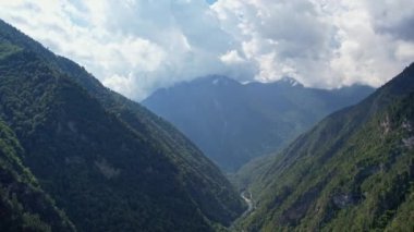 Ormanla kaplı üç dağ arasındaki vadi panoraması dağ nehri vadiye akar ve dağların üzerinden geçen bir otoyol geçer. Yüksek kalite 4k görüntü