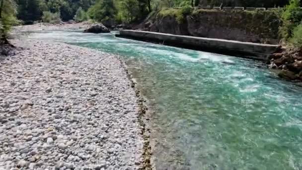 相机在山河上的飞行是绿色的 河岸上有卵石和森林 前面有一个小急流 高质量的4K镜头 — 图库视频影像