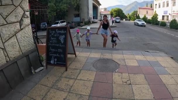 Eine Mutter Führt Drei Kleine Töchter Den Händen Entlang Der — Stockvideo