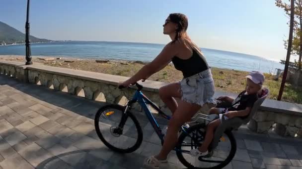 Matka Dzieckiem Jeździ Rowerem Wzdłuż Nadbrzeża Morskiego Jej Córka Siedzi — Wideo stockowe
