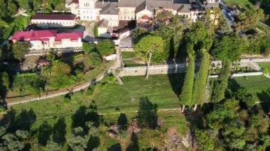 Abhazya 'daki yeni Athos Manastırı, Yeni Athos şehri, İHA görüntüleri, sonbahar yeşil tepeleri ve mavi deniz, batan güneşte parıldayan kiliselerin altın kubbeleri, Ortodoks haçları, selvi ağaçları ve palmiye ağaçları.