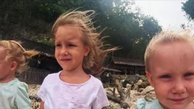 Küçük kızlar, kız kardeşler, rüzgar saçlarını uzatır, sahilde dururken okyanusa bakarlar kız kardeşler rüzgarda durur ve geleceğe bakarlar.