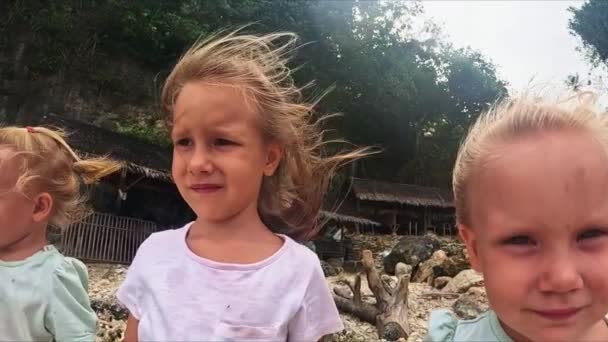 小女孩 姐姐们 风吹拂着头发 她们站在沙滩上看着大海 三姐妹站在风中向前看 — 图库视频影像
