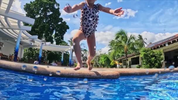 Ein Kleines Mädchen Springt Von Der Seite Den Pool Völlig — Stockvideo