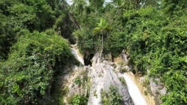 Filipinler 'deki güzel bir şelalenin insansız hava aracı görüntüleri tropikal bir ada olan Şelale' deki derin bir boğazda mavi yeşil suyla mavi yeşil su dronu ile. Yüksek kalite 4k görüntü