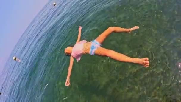 Okyanusta Suyun Üzerinde Yatmayı Öğrenen Bir Kız Yüksek Kalite Görüntü — Stok video
