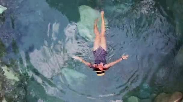 熱帯の島の山の川で火山性の温泉の青いお湯温泉で黒水着でドローンガールから撮影 高品質4K映像 — ストック動画