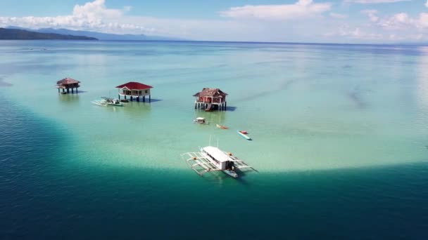 Baisフィリピン白い砂が熱帯の山の島々の間に干潮を吐き出す青い海の水のボート山の雲 — ストック動画