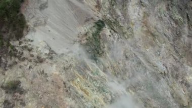 Volkanik gazın beyaz dumanları, ormanla kaplı tropikal bir adada volkanın yamaçlarından yükselir. Filipinler 'de sıcak sülfür taşları tüten dağ volkanı. Yüksek kalite 4k görüntü