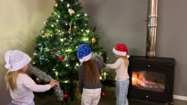 Tiga Adik Perempuan Kembar Tiga Menghiasi Pohon Natal Dengan Mainan — Stok Video